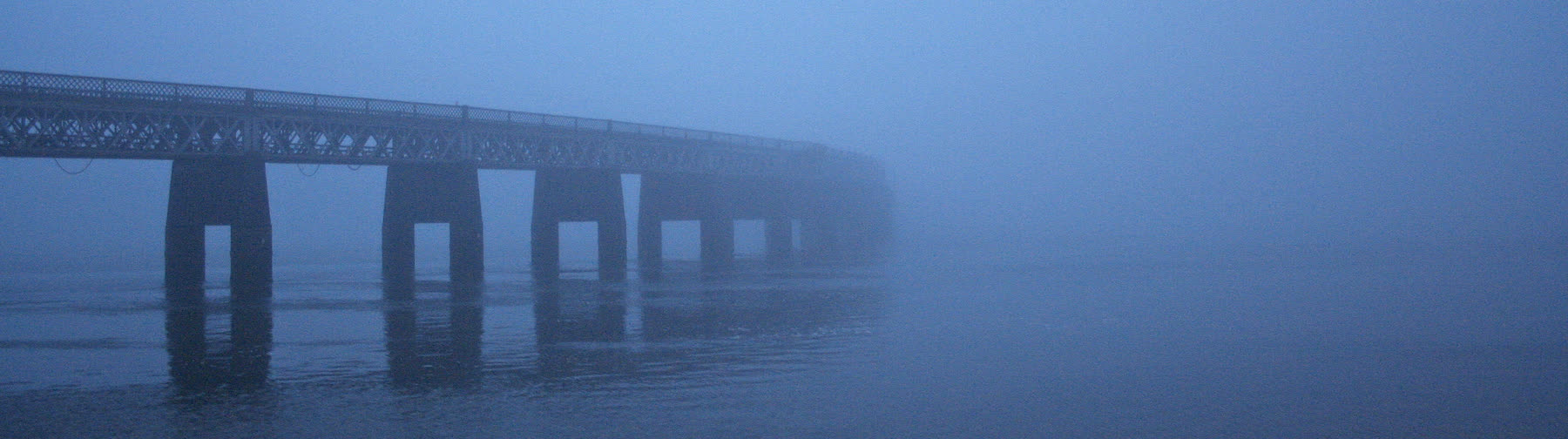 The Tay Rail Bridge disappearing into fog over the river.